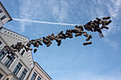 Zusammengebundene Schuhe hängen in der Innenstadt auf einer Leine, Shoefiti, Flensburg, Flensburger Förde, Ostsee, Schleswig-Holstein, Deutschland