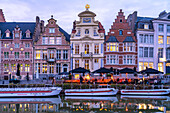 Gastronomy and historic houses on Korenlei quay on Leie river at dusk, Ghent, Belgium