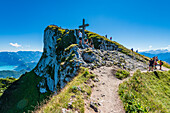 Gipfelkreuz und Felswand am Schafberg mit Blick auf den Attersee und das Höllengebirge, Salzkammergut, Österreich