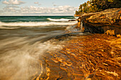Langzeitbelichtung der Wellen am Lake Superior im Herbst, abgebildet Rocks National Lakeshore, obere Halbinsel von Michigan.