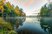 Herbstfarben und Nebel reflektieren Council Lake bei Sonnenaufgang, Hiawatha National Forest, obere Halbinsel von Michigan.