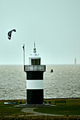 Ein Kitesurfer umrundet den Leuchtturm "Kleiner Preuße" in Wremen, Landkreis Cuxhaven, Niedersachsen, Deutschland