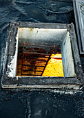 Manhole with ladder leading down from roof