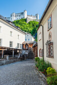 Gasse in der Stadt Salzburg mit Blick auf die Festung Hohensalzburg, Österreich