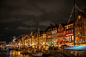 View of the harbor of Nyhavn in Copenhagen in the evening in Advent, historic sailing ships, Denmark