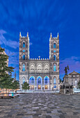 The Notre Dame Basilica, lit up at dusk in the city square in the Old Town of Montreal.