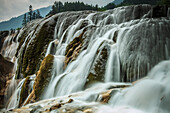 Jiuzhaigou Waterfall, water cascading over rocks in a national park, at Unesco world heritage site.