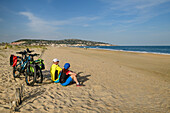 Zwei Personen beim Radfahren machen am Strand von Sete Pause, Sete, Canal du Midi, UNESCO Welterbe Canal du Midi, Mittelmeer, Okzitanien, Frankreich