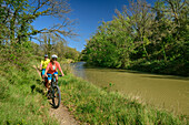Two people cycling along the Canal du Midi, near Marseillette, Canal du Midi, UNESCO World Heritage Canal du Midi, Occitania, France