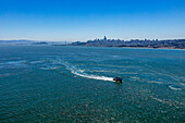 Usa, California, San Francisco, High angle view of ferry on bay with city skyline in distance