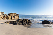 Blick auf Felsformationen und Wellen am Meer, Hermanus, Südafrika