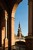 Spain, Seville, Arch bridge and bell tower at Plaza de Espagna