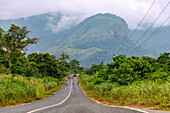 Landstraße in der Regenwaldlandschaft bei Hohoe in der Volta-Region im Osten von Ghana in Westafrika