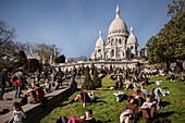 Crowds of people relaxing on the grassy areas in front of the Basilica &quot;Sacré-Cœur de Montmartre&quot;, Capital Paris, Ile-de-France, France