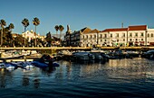 Blick über den Yachthafen auf die Seepromenade und Gebäude der Altstadt von Faro, Algarve, Portugal
