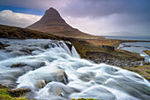 Der Berg Kirkjufell mit dem Wasserfall Kirkjufellsfoss auf Island, Island.