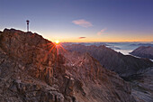 Sunrise at the summit cross of the Zugspitze, Bavaria, Germany