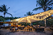 People enjoy dinner and drinks at the beach bar and restaurant at L&#39;Anse Aux Epines Cottages, near Saint George&#39;s, Saint George, Grenada, Caribbean