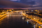 Aerial view from river cruise ship Excellence Empress (Mittelthurgau travel agency) overlooking Szechenyi Chain Bridge over Danube River and Fisherman's Bastion at night, Budapest, Pest, Hungary, Europe