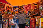 Friendly woman with a welcoming gesture at a handicraft and souvenir stall in Punda, Willemstad, Curaçao, Netherlands Antilles, Caribbean
