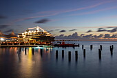 Karels Beach Bar auf Steg mit Expeditionskreuzfahrtschiff World Voyager (nicko cruises) am Pier in der Abenddämmerung, Kralendijk, Bonaire, Niederländische Antillen, Karibik