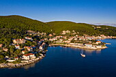 Luftaufnahme der Stadt und Bucht von Fiskardo mit Segelboot, Fiskardo, Kefalonia, Ionische Inseln, Griechenland, Europa