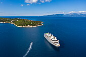 Aerial view of expedition cruise ship World Explorer (Nicko Cruises) and the Fiskardo Peninsula, Kefalonia, Ionian Islands, Greece, Europe