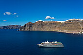 Aerial view of expedition cruise ship World Explorer (nicko cruises) in anchorage with the cliff houses of Oia behind, Santorini, South Aegean, Greece, Europe