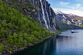 Aerial view of expedition cruise ship World Voyager (nicko cruises) passing Seven Sisters waterfall in Geirangerfjord, Geiranger, Møre og Romsdal, Norway, Europe