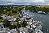 Aerial view of town, fishing boats in Fowey Harbor and expedition cruise ship World Voyager (nicko cruises), Fowey, Cornwall, England, United Kingdom, Europe