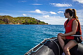 Young woman during Zodiac inflatable boat transfer from boutique cruise ship M/Y Pegasos (Variety Cruises), Curieuse Island, Seychelles, Indian Ocean
