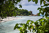 Two people stroll along beach, La Digue Island, Seychelles, Indian Ocean