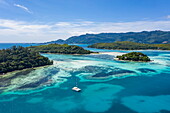 Aerial view of a sailing catamaran in clear turquoise waters with islands behind, St Anne Marine National Park, near Mahé Island, Seychelles, Indian Ocean