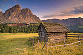 Small wooden hut at sunset in front of the Peitlerkofel, South Tyrol, Italy.
