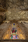 Looking up at the vaulted ceiling and stained glass windows of the Monastery Church of Jeronimos Monastery in Belem, Lisbon, Portugal