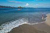 Aerial view of a woman walking on the beach with expedition cruise ship World Voyager (nicko cruises) in the distance, Isla Tortuga, Puntarenas, Costa Rica, Central America
