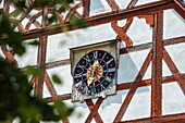 Clock on the wall of a half-timbered house, Gerolfingen, Irsingen, Franconia, Bavaria, Germany, Europe