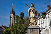 Statue on a bridge in the old town with cathedral, Bruges, West Flanders, Belgium, Europe