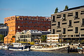 Lastkähne am Fluss Saône und Gebäude mit moderner Architektur im Stadtteil Confluence, Lyon, Rhône, Auvergne-Rhône-Alpes, Frankreich, Europa