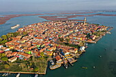 Aerial view of river cruise ship SS La Venezia passing Burano island with its colorful houses, Burano, Venice, Italy, Europe