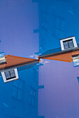Double exposure of a orange residential building against a clear blue sky in Tartu, Estonia.