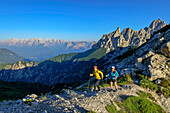 Mann und Frau wandern auf Wanderweg am Bergkamm, Forcella di Zita, Belluneser Höhenweg, Dolomiten, Venezien, Venetien, Italien