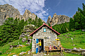 Woman opens door at the Bivacco Campestrin hut, Bosconero Group, Dolomites, Veneto, Veneto, Italy