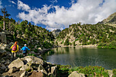 Man and woman hiking along the Estany de Gerber lake, Valle Gerber, Aigüestortes i Estany de Sant Maurici National Park, Pyrenees, Catalonia, Spain