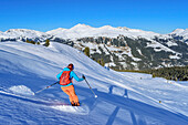 Woman on ski tour descends from Schönbichl, Schönbichl, Zillertal Alps, Tyrol, Austria