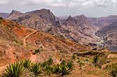 A scenic mountainous landscape with a valley and agaves in the foreground in the center of Santiago Island, Cape Verde