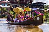 Procession and ceremony for the ordination of a young Burmese Buddhist monk on a longboat in Inle Lake, Myanmar