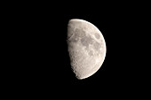 Telephoto shot of the moon with many craters, mountains and mare in front of a black sky