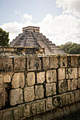 Totenköpfe im Gestein an 'Tzompantli' mit Blick zur Kukulcán-Pyramide (auch El Castillo) in der Ruinenstadt Chichén-Itzá, Yucatán, Mexiko, Nordamerika, Lateinamerika, Amerika