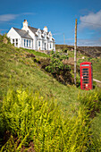 Weißes Landhaus bei Colbost mit roter Telefonzelle, Glendale, Isle of Skye, Highlands, Schottland, Großbritannien